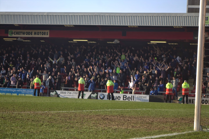 Oldham Athletic fans celebrate a 1-0 victory away to Crewe in league 1