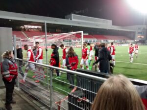 The players walk across the concourse of the stadium.